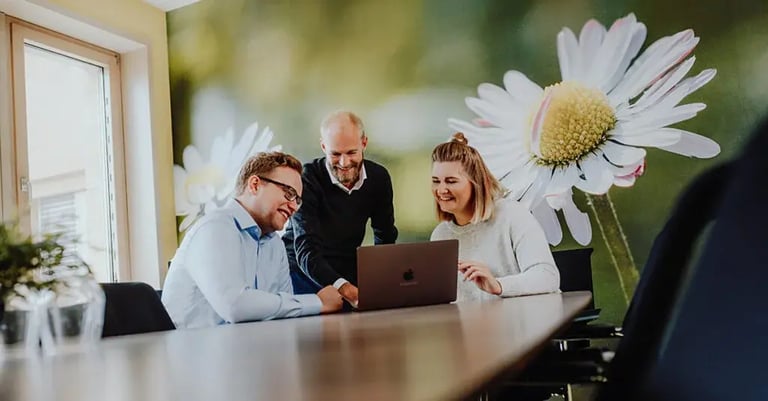 Symbolbild: Ein agiles Team arbeitet zusammen an einem Laptop