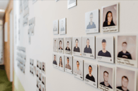 Galerie aus Polaroids der basecom Mitarbeitenden an einer Bürowand